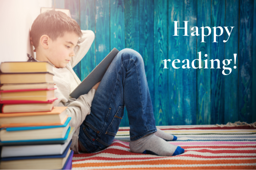 Boy reading behind a pile of books