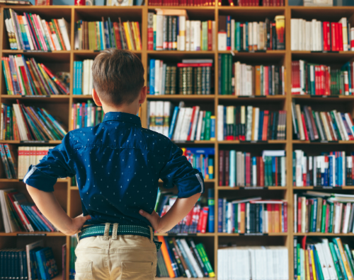 Boy looking at library shelves