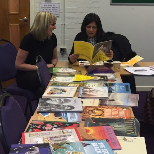 teachers looking at selection of picture books